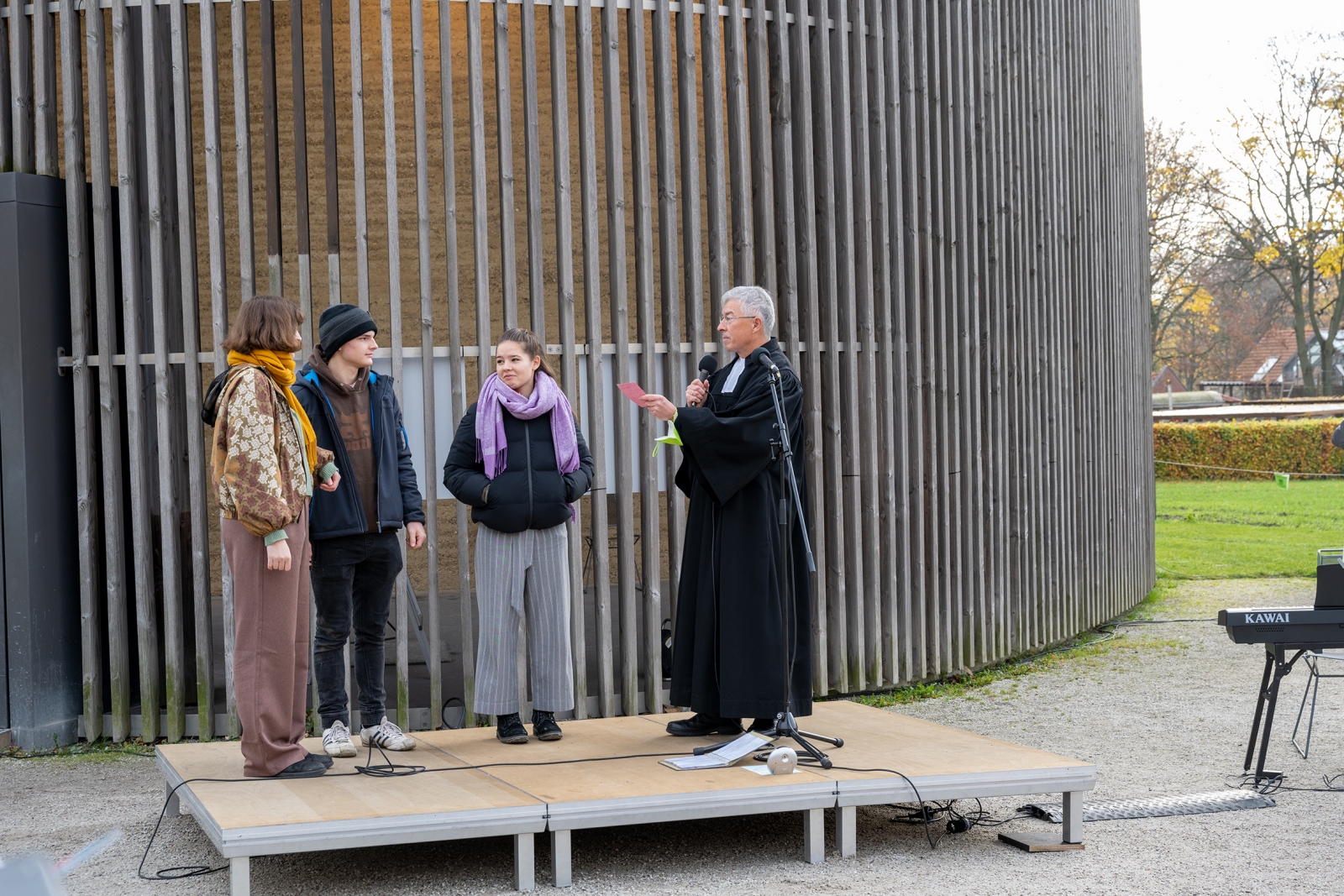 Drei Jugendliche und Pfarrer Jeutner vor der Kapelle der Versöhnung